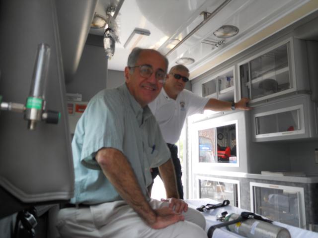 Father DeMartino receives a tour of ambulance from Bob Zink.